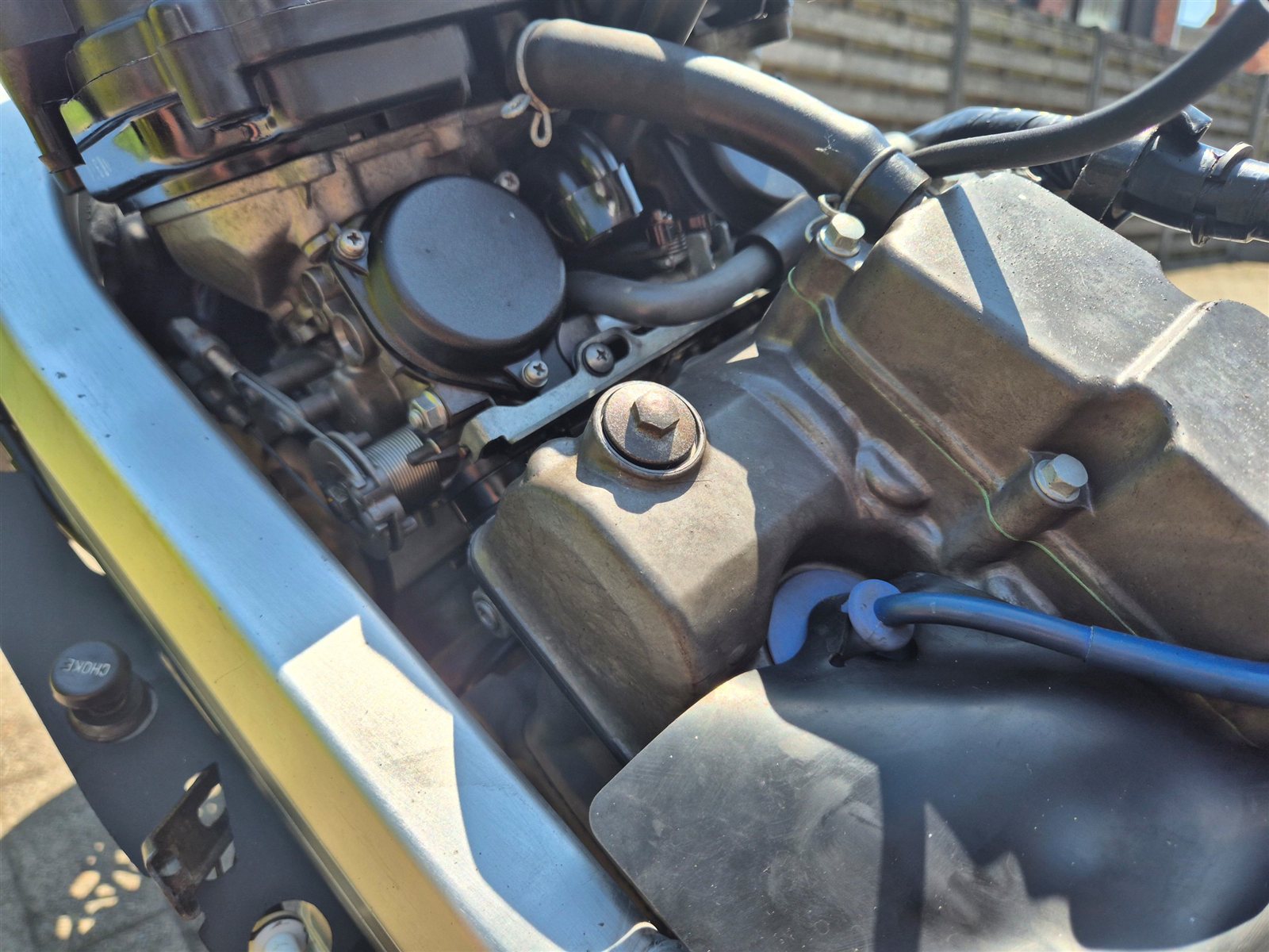 Engine bay of a Honda RVF400R with the fuel tank removed, showing the carburettors