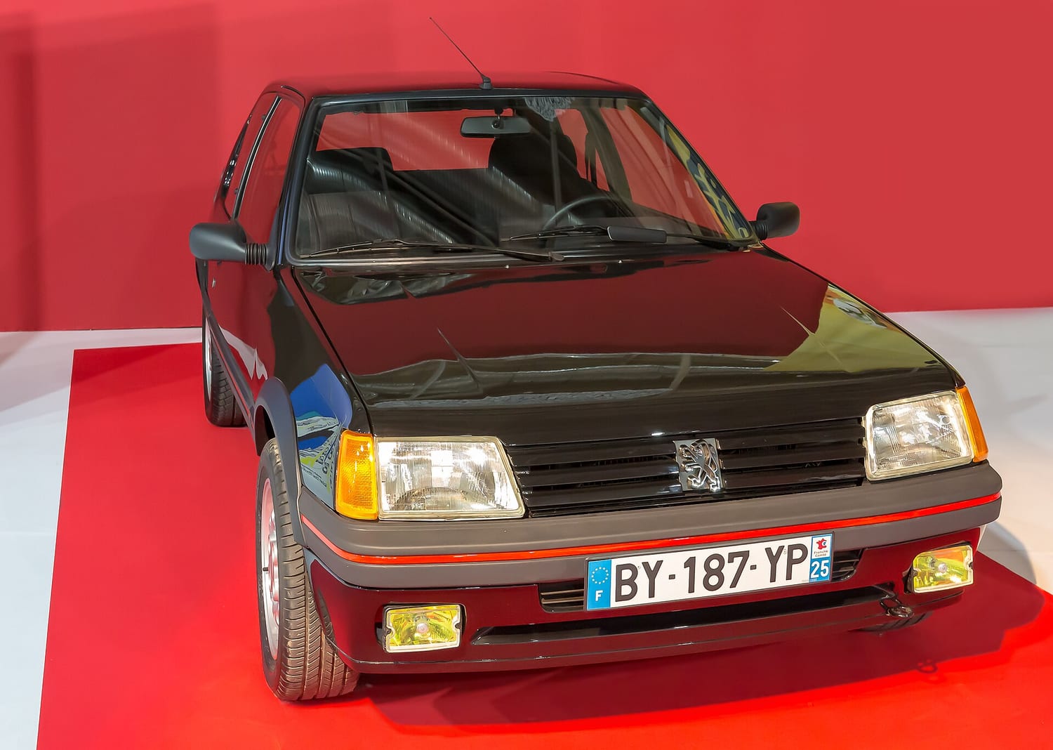 Peugeot 205 GTI seen from the front on a red display stand